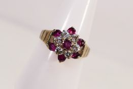 A lady's hallmarked cluster ring set with rubies and diamonds, size O+1/2, approx weight 3.22 grams.