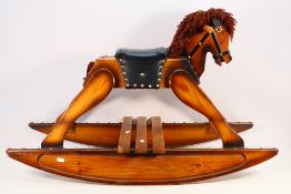 A child's wooden rocking horse with decorative stud work and woolen mane,