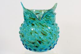 A glass vase in the form of an owl, blue / green colour with tan swirls, approximately 22 cm (h).