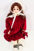 Bisque & Leather Doll - An antique bisque headed doll with composite body with jointed leather legs,