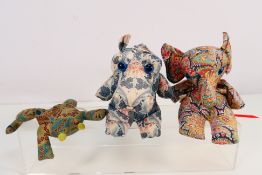 Three Liberty Of London bean bag creatures comprising a dragon, elephant and frog,