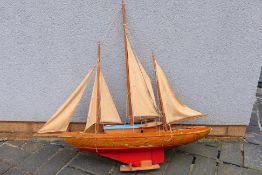A scratch built wooden yacht, which measures approximately 82 cms (L) x 18 cms (W) x 80 cms (H).