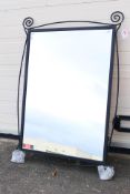 A wrought iron framed wall mirror, approximately 107 cm x 73 cm.