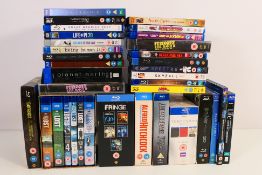 A collection of Blu-ray and DVD discs / box sets comprising feature films, television series,