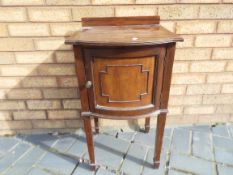 A mahogany bedside pot cupboard with single door, raised on four supports with spade foot terminals,