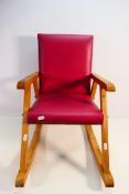 A child's rocking chair with leather effect upholstery.