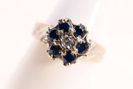 An 18ct white gold sapphire and diamond cluster ring with six sapphires surrounding an illusion set