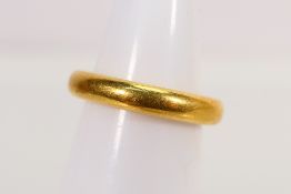 A 22ct gold wedding band, size I+½, approximately 8 grams.