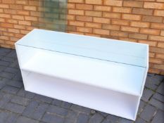Two white glass topped display units with single glass shelves,
