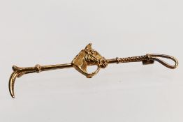 A 9ct gold horse head and riding crop bar brooch, 6 cm (l), approximately 3 grams.