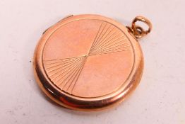 A 9ct rose gold pendant locket with engraved decoration, 2.5 cm (d), approximately 3.4 grams.