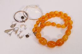 A collection of white metal jewellery to include christening bangle, bangle with flower head motif,