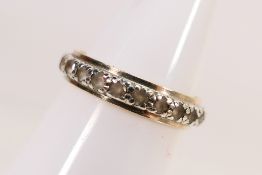 A two-tone metal stone set eternity ring, stamped 9ct, size O, approximately 3 grams.