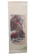 An Oriental hanging scroll with landscape village scene, signed, approximately 135 cm x 53 cm.