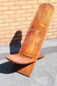 A solid wood African birthing chair in two parts, carved with elephant, eagle, fish and palm tree,