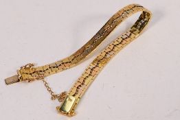 A tri-tone metal bracelet, stamped 750, with box clasp and safety chain, approximately 17 cm (l),