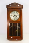 A vintage wood cased wall clock with carved decoration, Arabic numerals to the dial, with pendulum,