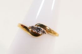 A 9ct yellow gold ring set with three small diamonds, size K+½, approximately 1.2 grams.