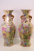 A large pair of Chinese vases with floral decoration against a yellow ground,