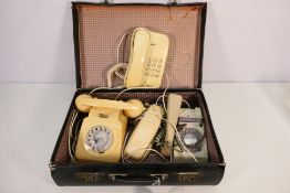A small case containing four vintage telephones, two dial examples.