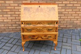 A writing bureau with fall front having fitted interior over three drawers,