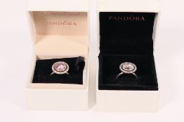 Two boxed Pandora Halo rings, the first with a pink stone with clear surround, the other with clear,