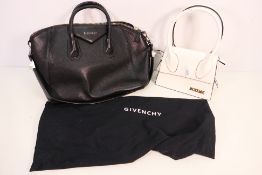 Two handbags, one with protective dust cover.