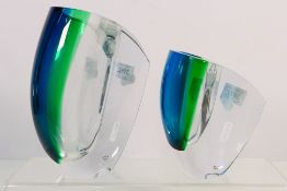Kosta Boda - A graduated pair of glass vases designed by Goran Warff in blue, green and clear glass,