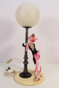 A vintage figural table lamp depicting The Pink Panther leaning against a lamp post,