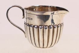 A small, late Victorian milk jug with gadrooned decoration, Sheffield assay 1899,
