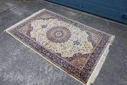 A Persian design rug with circular medallion to an ivory field decorated with trailing floral