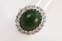 A white metal stone set ring with centra