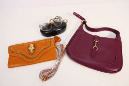 Two handbags and a pair of fashion sunglasses contained in protective case.