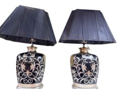 Pair of black and silver floral decorated table lamps and shades.