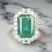 An 18ct white gold emerald and diamond cluster ring,