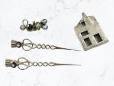 Four silver brooches including one in the form of a house, another abstract example,