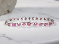 An 18ct white gold ruby and diamond line bracelet,