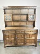 An Ercol elm dresser with leaded glass doors, 151 cm x 47 cm x 177 cm.