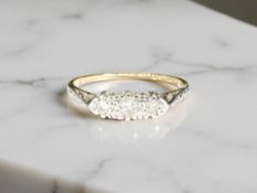 A diamond three-stone ring, the brilliant-cut stones in an illusion setting,