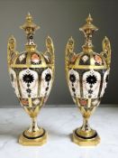 A pair of Royal Crown Derby Imari Pattern 1128 solid gold band twin-handled urns and covers,
