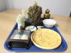 A Chinese carved pale green hardstone four legged dragon on wooden stand,