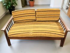 A teak-framed two seater low settee, width 137 cm.