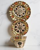 A Royal Crown Derby Imari porcelain teacup, saucer, and plate trio, filled gold band border,