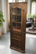 A reproduction carved oak corner cabinet, height 178 cm.