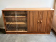 A 20th century walnut low bookcase, with cupboards and sliding glass doors beneath,
