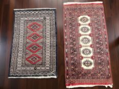 A Lahore Bokhara rug, Pakistan, 125 cm x 63 cm, together with a further similar rug.