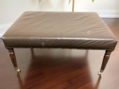 A Victorian-style rectangular studded brown leather upholstered footstool on turned mahogany legs,