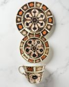 A Royal Crown Derby Imari porcelain teacup, saucer, and plate trio, unfilled gold band border,