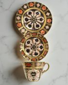 A Royal Crown Derby Imari porcelain teacup, saucer, and plate trio, filled gold band border,