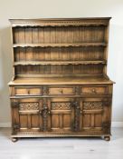 A reproduction carved oak dresser, 154 cm x 48 cm x 183 cm.